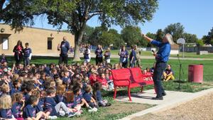 Principal Harman talks with the kids on the lawn.