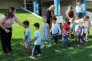 Preschool children line up in front of the podium to say thank you to grant officials