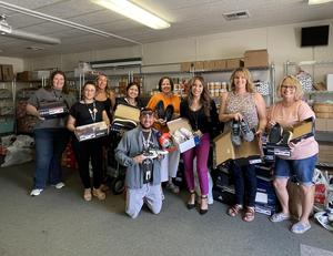 Realtors pose with FCRC coordinators and the donated shoes