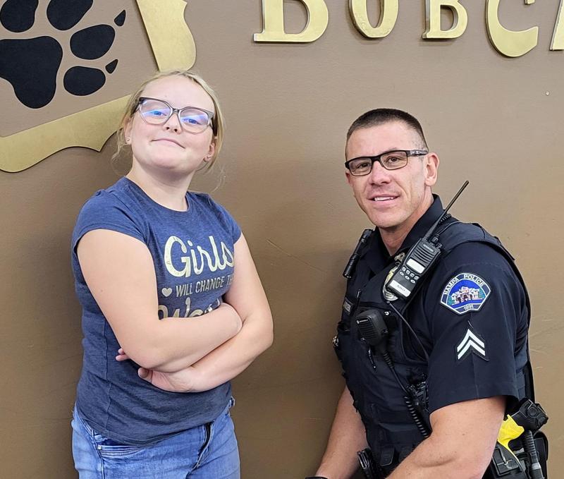 EVMS girl and Jared Hoeksema pose in front of Bobcat wall decor.