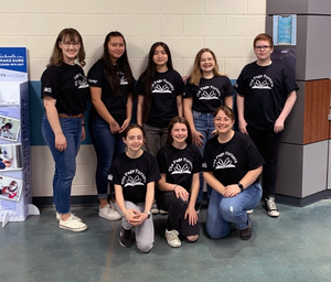 8 members of the Page Turners team pose in shirts with team name