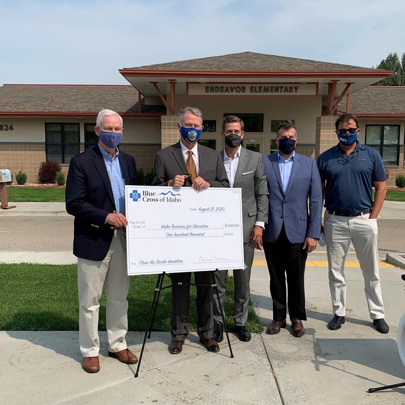 Gov. Brad Little poses with Blue Cross and IBE representatives in front of Endeavor Elementary.
