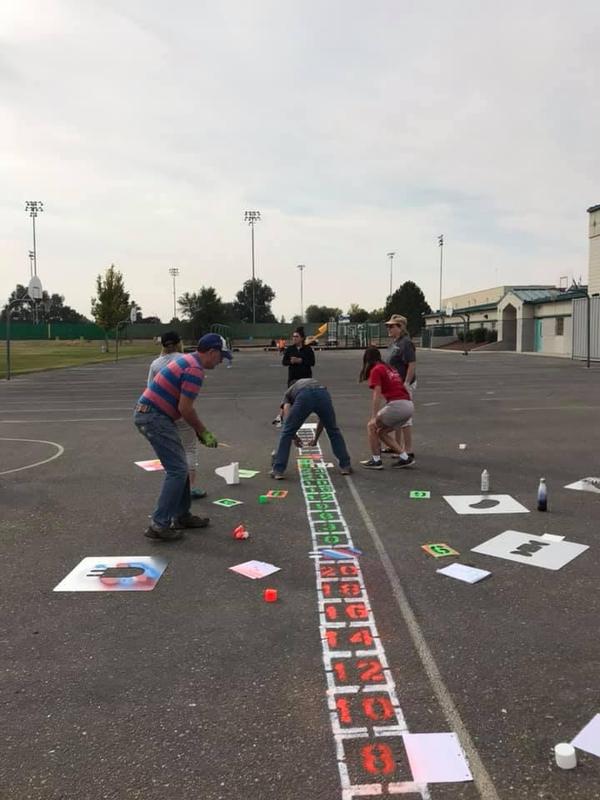 Volunteers help paint the number line at Snake River Elementary.