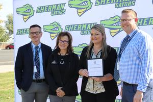 Superintendent, mayor, principal and former principal pose with certificate