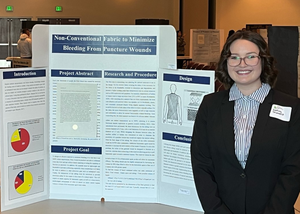 Nakiah Shanafelt stands in front of her presentation board.