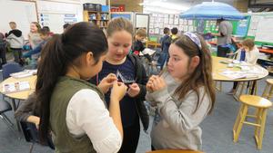 Three girls act out the word \"clue.\"