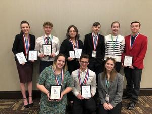 Eight BPA students pose with their winning certificates.