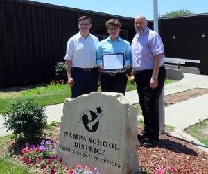 Braeden Watkins poses with Coach Jeffrey Stoppenhagen and Assistant Coach Ben Smoldon in front of the Nampa School District offices.