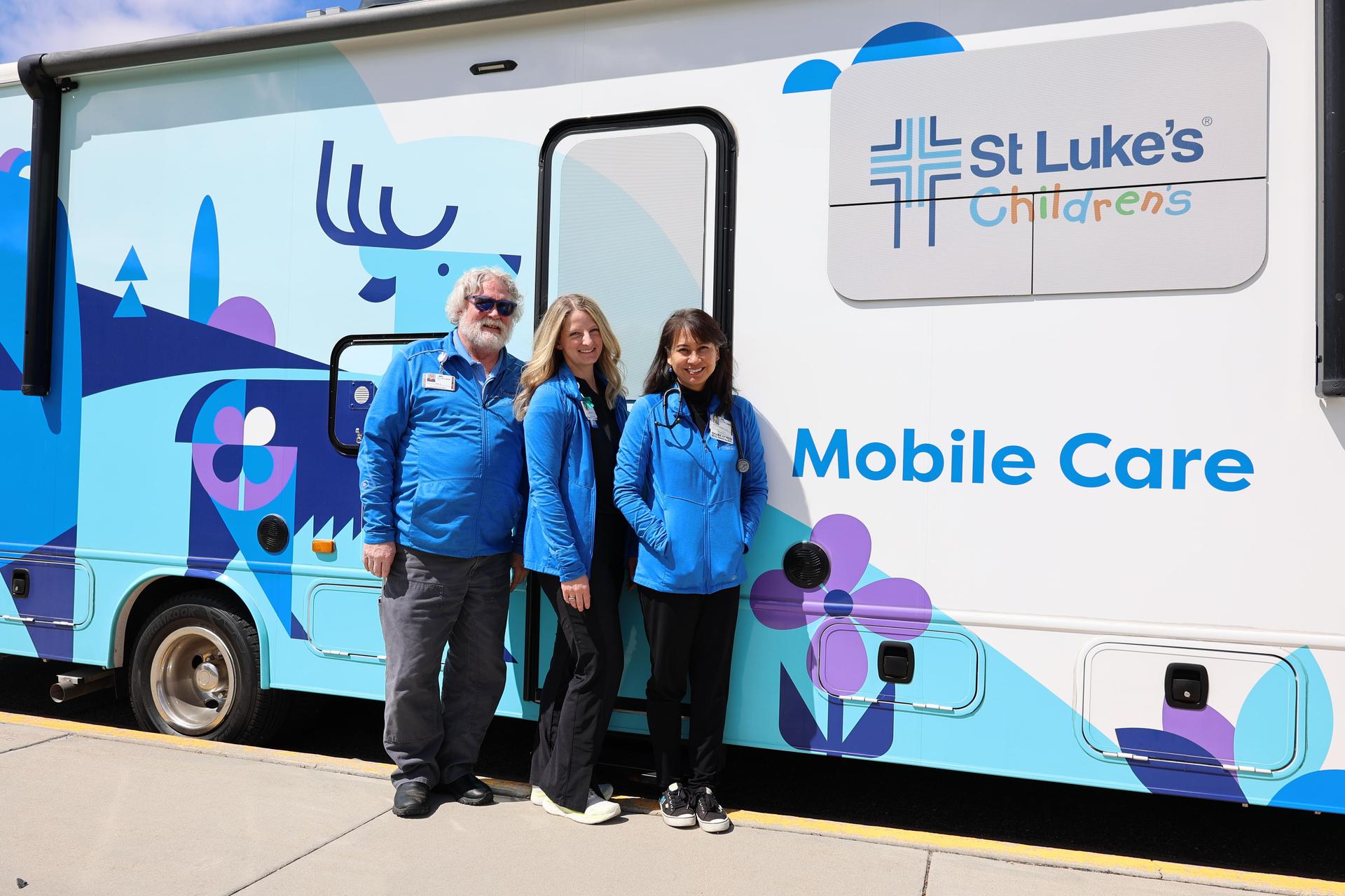 The care team poses outside the mobile clinic.