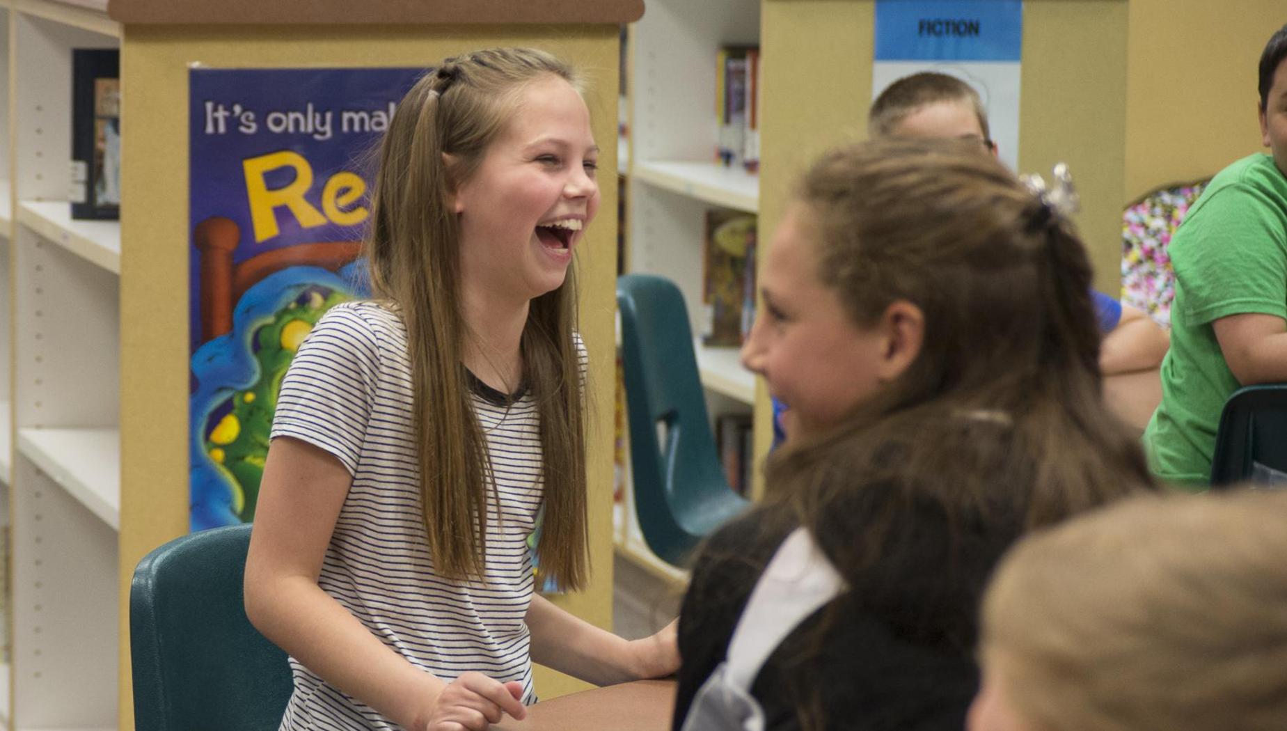 Girl laughs with her friends in the library
