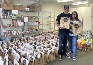 Danny and Shari Panasiuk stand amid dozens of food donation bags and canned goods.