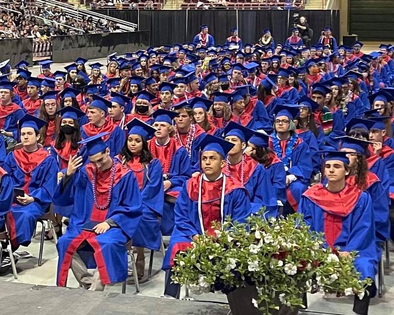 Nampa High students sit in their caps and gowns in the Ford Idaho Center arena.