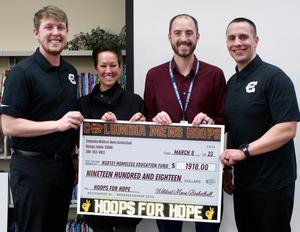 Four people holding \"big check\" for $1,918.