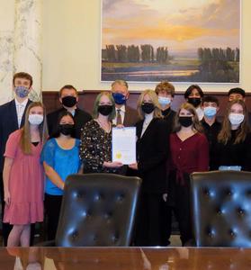 A close crop of the students posing with the governor and the proclamation at the Statehouse governor\'s office.