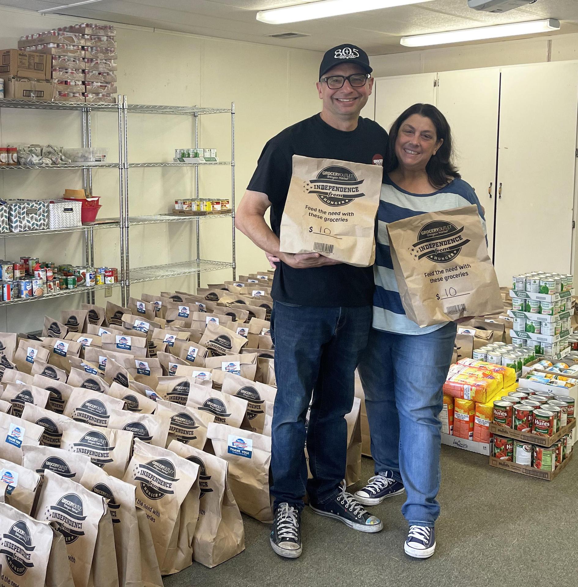 Dan and Shari Panasiuk pose with dozens of food donation bags at an FCRC.