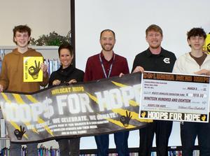 Five people holding \"big check\" and \"Hoops for Hope\" banner.