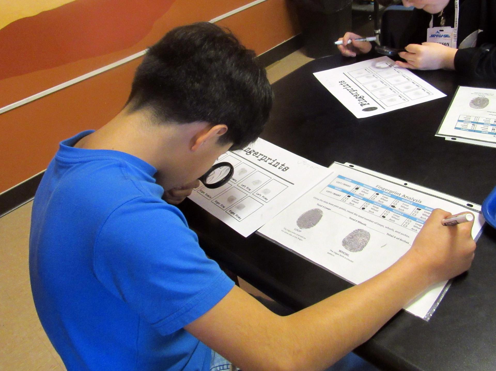 Young boy analyzes whorls in fingerprints.
