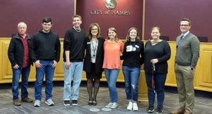 Photo students, teacher Terrell Moffett, Nampa Mayor Debbie Kling and NSD Superintendent Gregg Russell pose in the city council chambers.