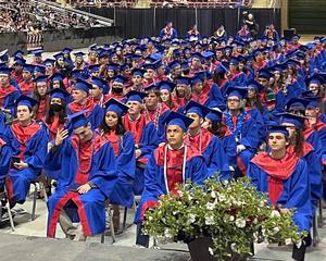 Nampa High students sit in their caps and gowns in the Ford Idaho Center arena.