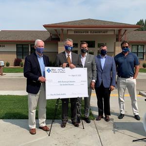Gov. Brad Little poses with Blue Cross and IBE representatives in front of Endeavor Elementary.