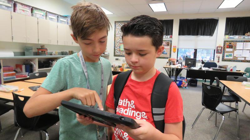 Two boys explore their iPad apps