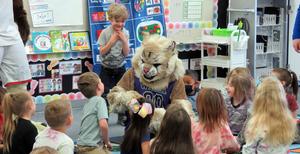 Kids gather around a bobcat mascot