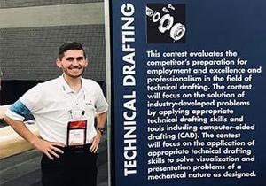 Ben Campbell stands in front of a Technical Drafting banner at the SkillsUSA competition.