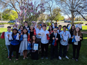 Group photo of speech and debate championship team with ribbons.