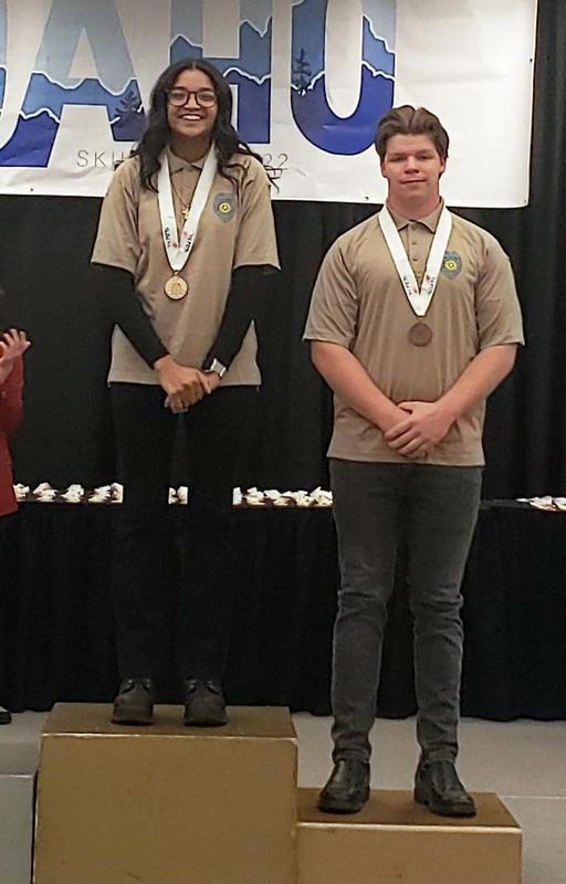 Abigail Cox stands with another winner (Parker Magnuson?) on the winner\'s podium.