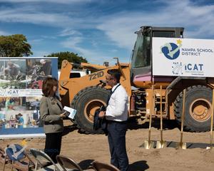 Mayor Kling and Superintendent Russell chat in front of heavy equipment at the groundbreaking.