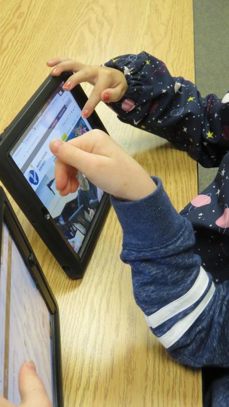 Image of hands pointing to the iPad screen.