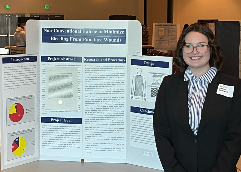 Nakiah Shanafelt stands in front of her presentation board.