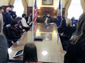 Skyview students sit at a table in the Governor\'s ceremonial office while they visit with him and ask questions.