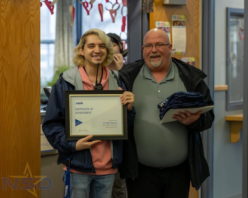 Freddy Munoz holds his certificate of achievement standing next to Shane Harrell.