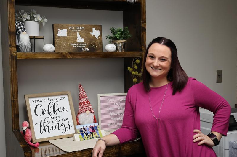 Terran in a bright pink shirt, leaning against a shelf