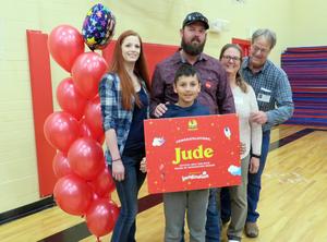 Jude Kelso poses with his parents and grandparents, along with balloons and a congratulationsposter.