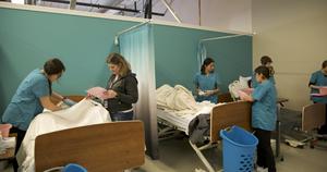 A female student and teacher work on a nursing mannequin.