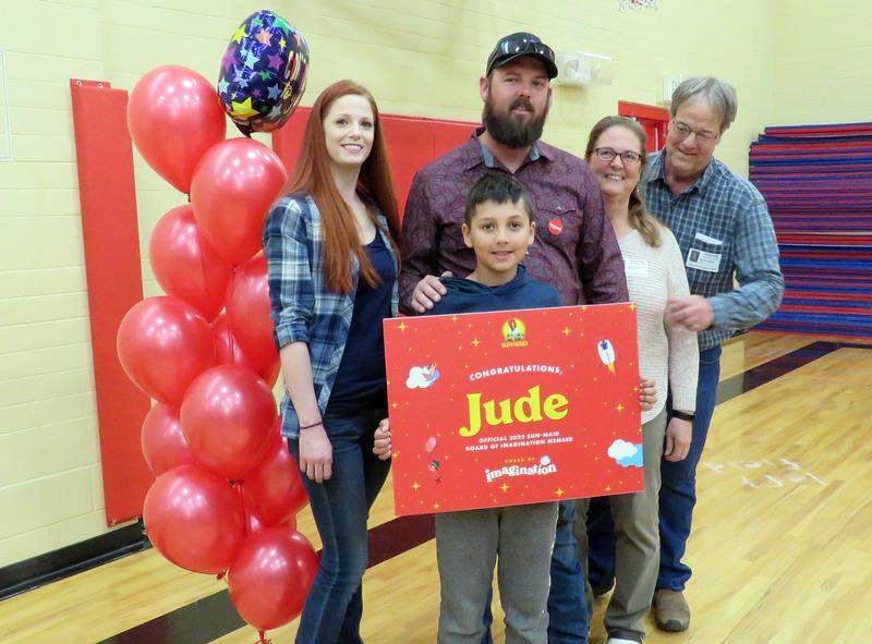 Jude Kelso poses with his parents and grandparents, along with balloons and a congratulationsposter.