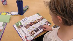 A girl reads vocabulary words based on fossils.