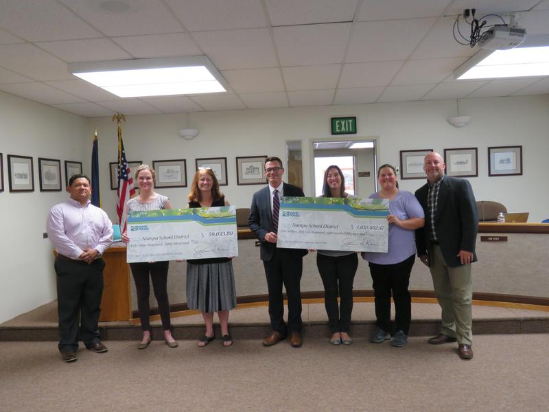 Idaho Power Reps present incentive checks to the Board.