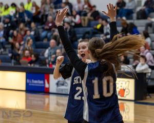 A male special education student in a Skyview jersey expresses joy as he is congratulated by a teammate.