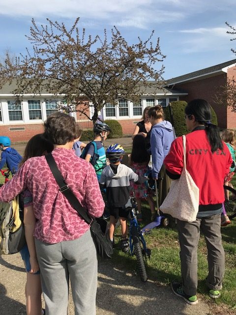 group of students and families standing outside the school