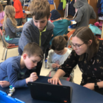 students and teacher with chromebook