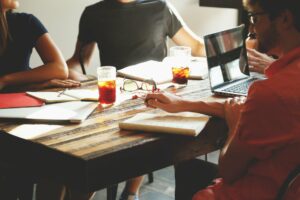 people around a work table appearing to be meeting.