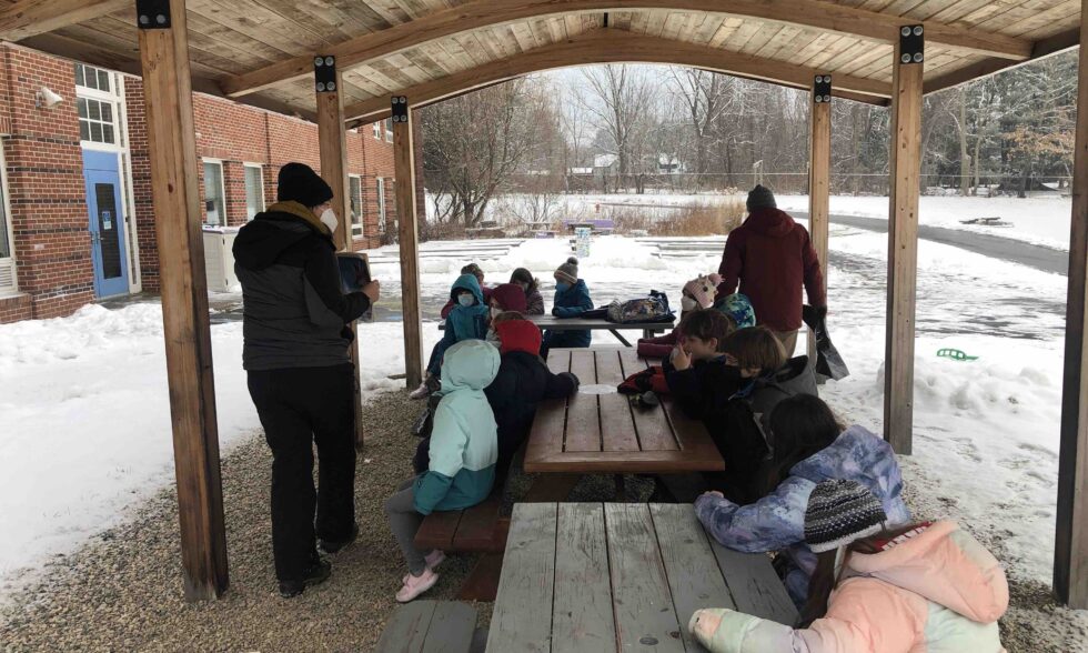 Student outside under a structure with snow around