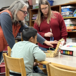 two teachers and student looking at piper computer.