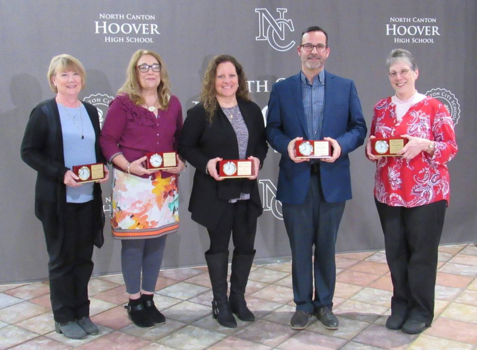 Four women and one man holding awards