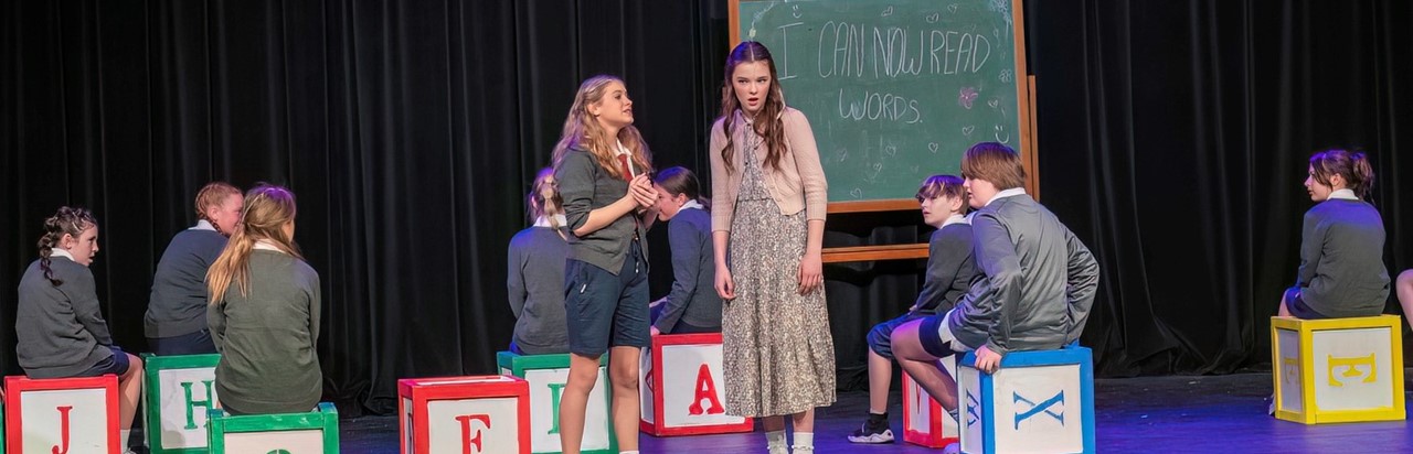 a scene from Matilda the Musical with Miss Honey and Mathilda in classroom
