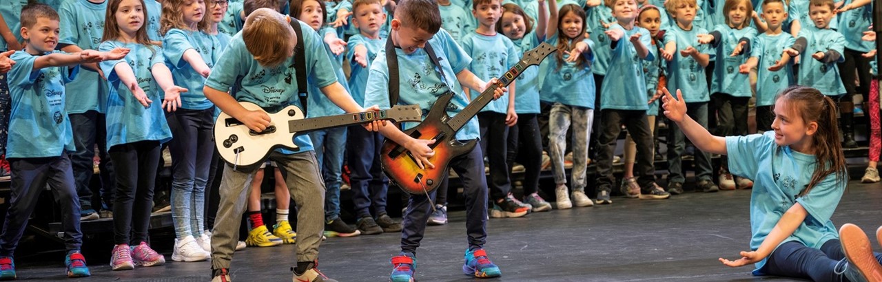 two second grade boys pretending to play the guitar
