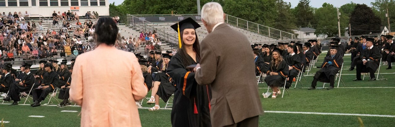 graduate receiving her diploma from board of education president